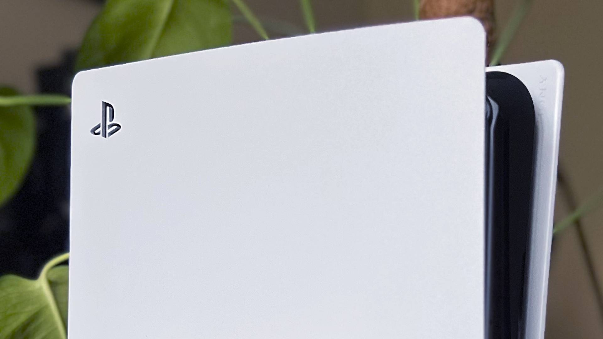 Close up of PlayStation logo on PS5 Pro with plant in backdrop.