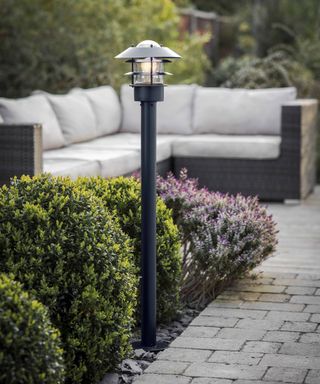 a garden light next to a brick pathway