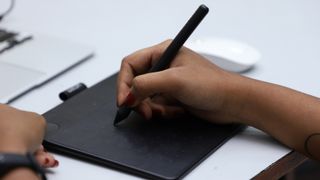 Woman's hand using stylus to draw on best drawing tablet