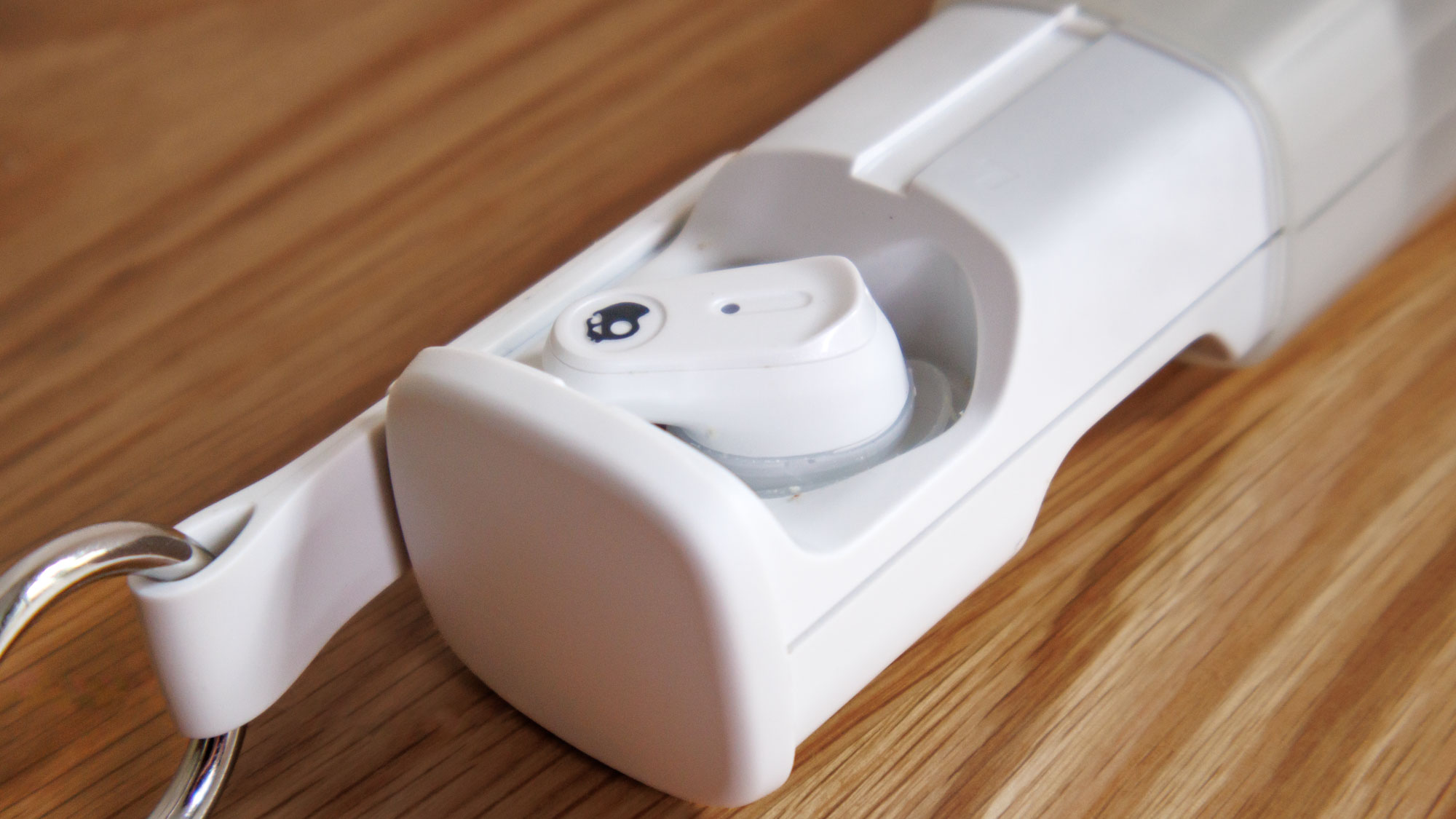 Skullcandy Method 360 ANC on a wooden surface, bud in the case