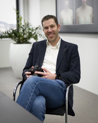 Leica SL System product manager, Steffen Rau, sat at a desk holding a Leica SL3