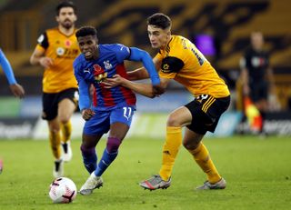 Crystal Palace’s Wilfried Zaha and Wolverhampton Wanderers’ Max Kilman (right) battle for the ball during the Premier League match at Molineux, Wolverhampton