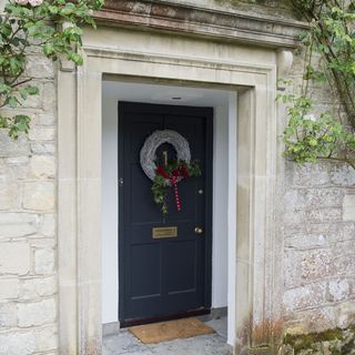 house entrance with deep blue door and wreath