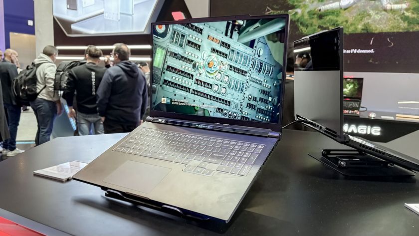 RedMagic 3D Gaming Laptop on display stand with people in the background 