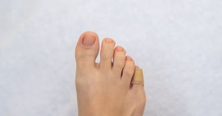 Foot with little toe wrapped in a bandaid