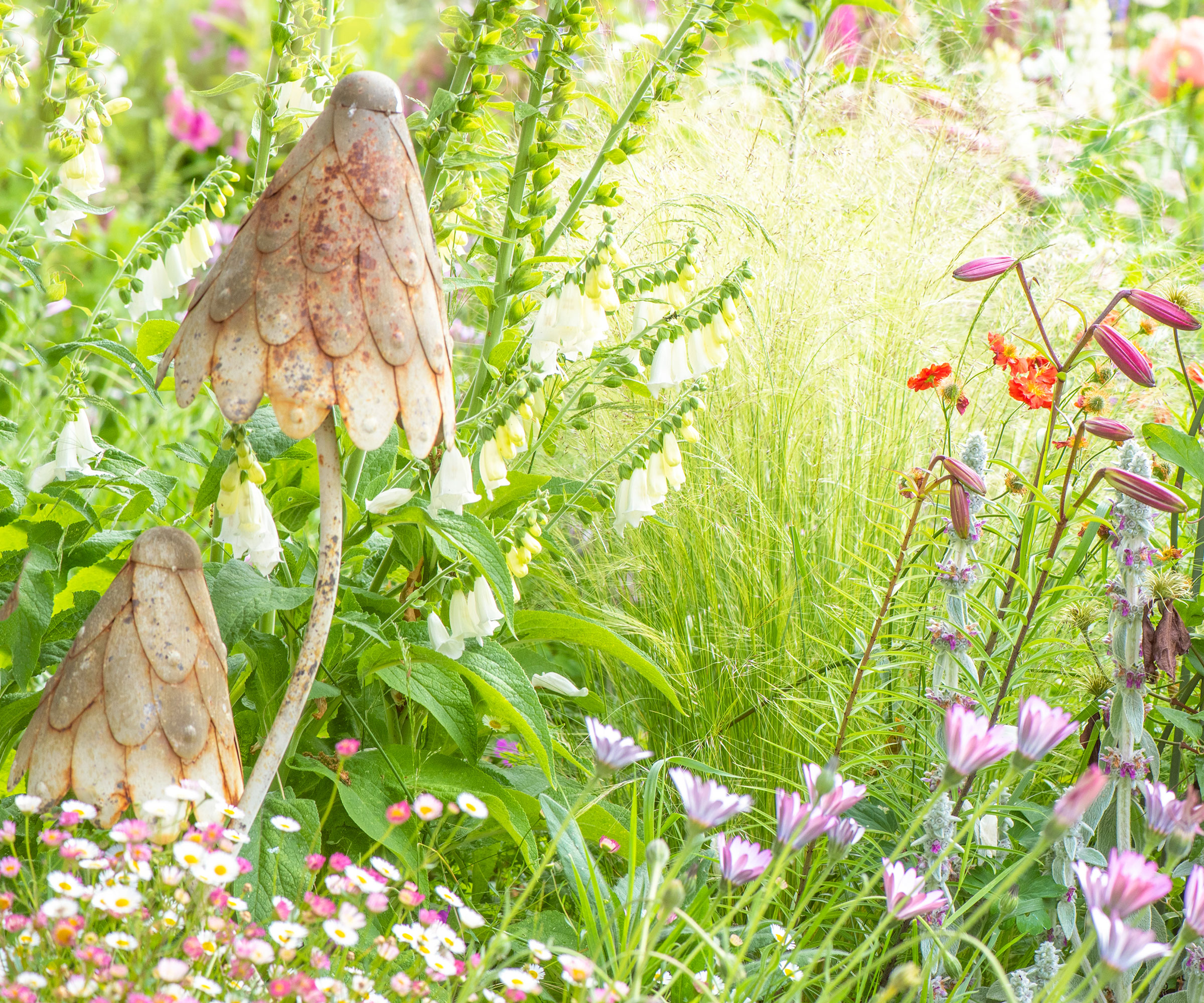 meadow planting with flowers and mushroom shaped metal ornaments