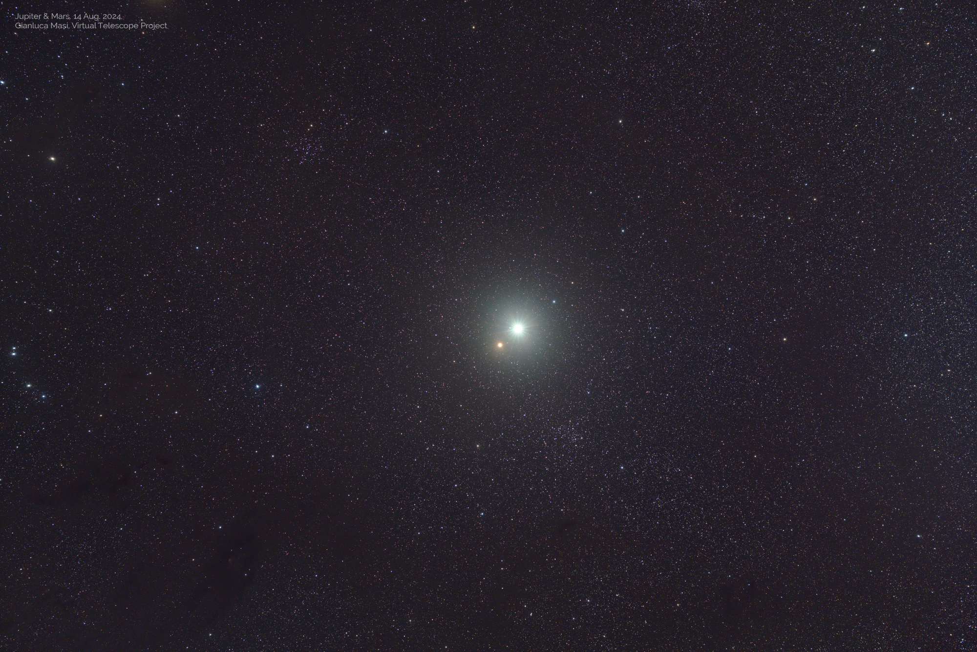 A star-studded sky with two bright points of light in the center, the bright white one is Jupiter and below to the left is red Mars.