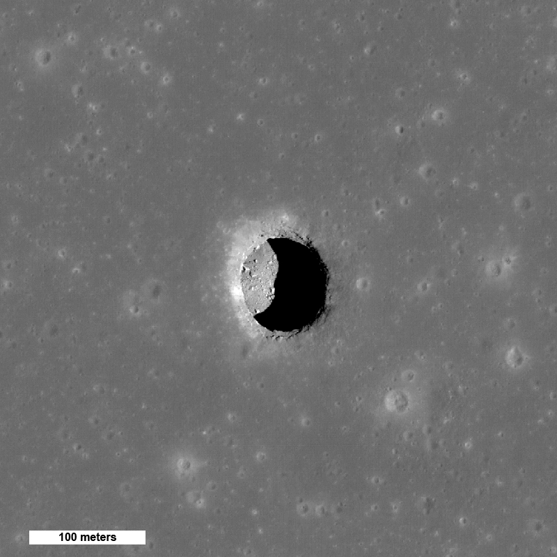 위에서 본 달 표면의 회색조 사진으로 얕은 분화구처럼 보입니다.