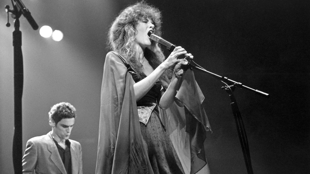 Stevie Nicks sings into a microphone.