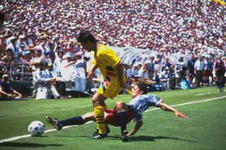 Romania's Ilie Dumitrescu is challenged by the USA's Cobi Jones in a match at the 1994 World Cup.