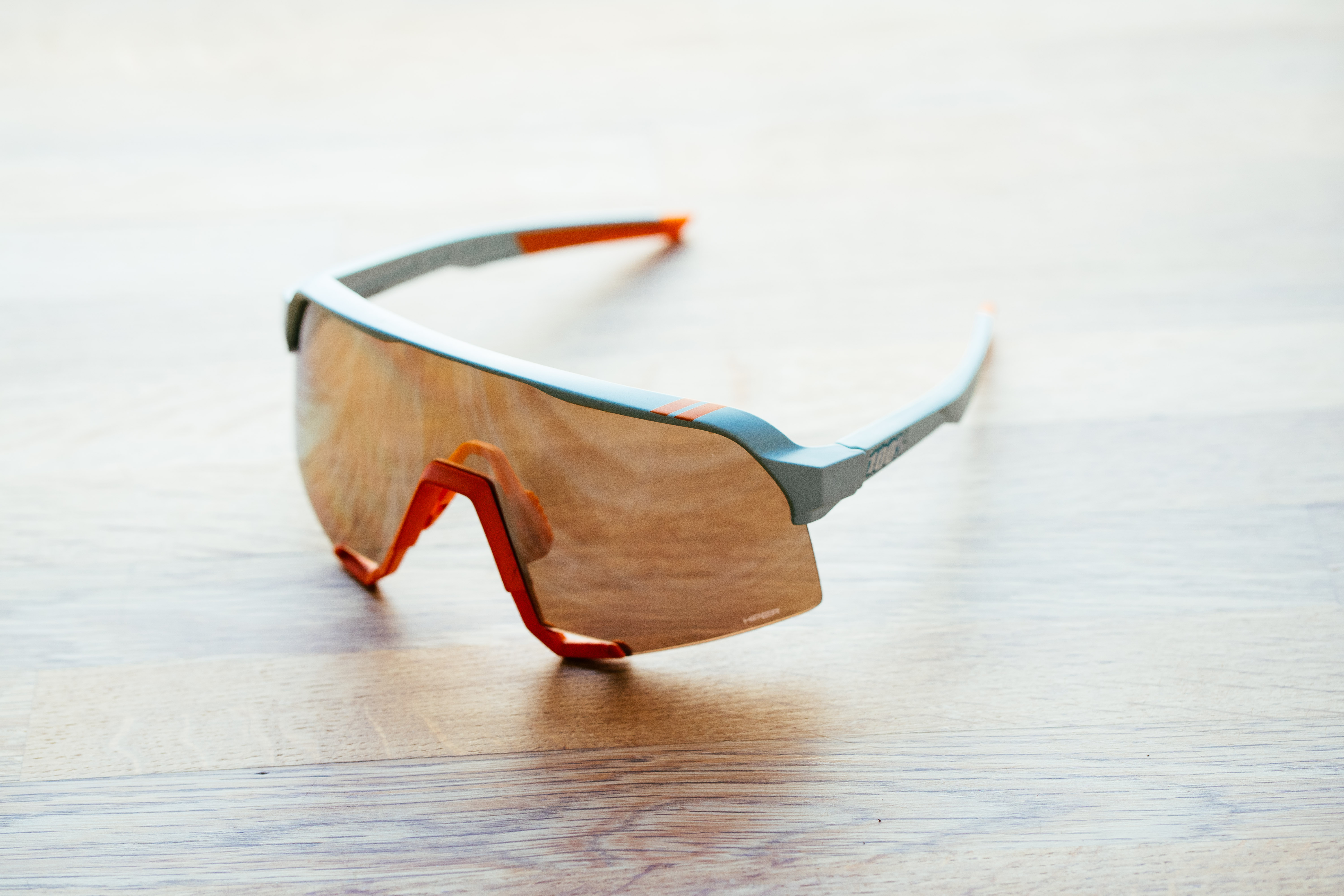 A blue framed set of sports glasses on a wooden surface