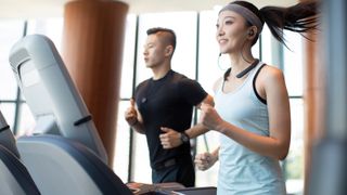 How a treadmill could boost your health at home: Two people run on treadmills for cardio exercise