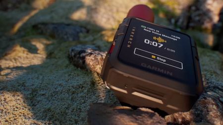 The Garmin InReach Mini 3 sitting on a rock, showing a new voice message.