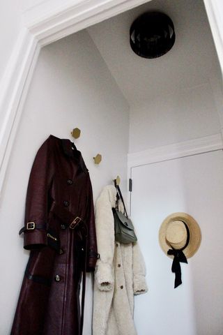 Cajayon's apartment entryway with coats and hat hanging up