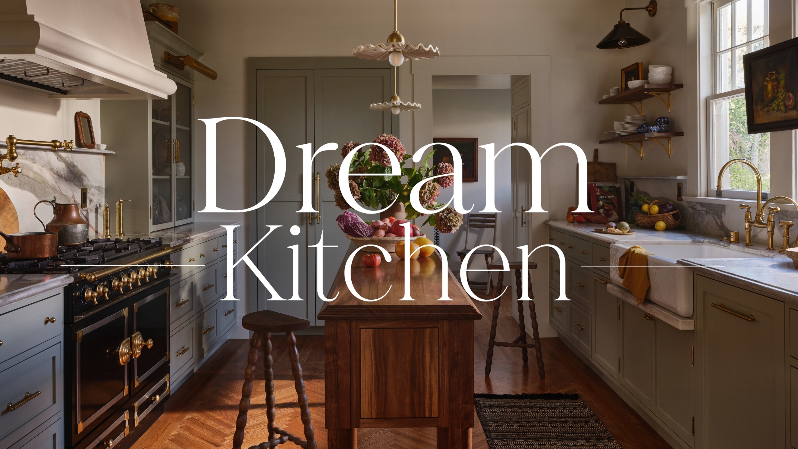A fall kitchen with soft green and muted blue cabinetry, warm white walls, a narrow wooden island, and marble countertops with a 'dream kitchen' text overlay