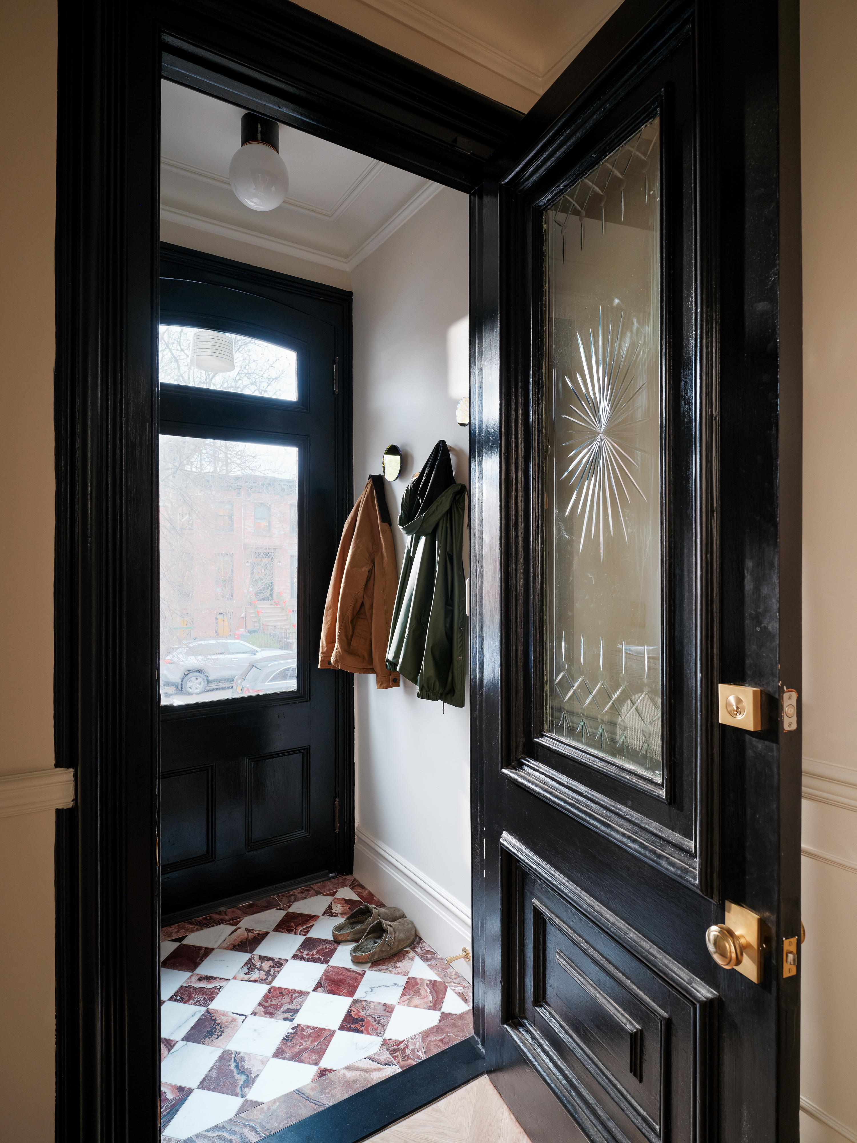 Coat room/entryway area of a historic NYC brownstone featruring marble red-and-white checkerboard floors