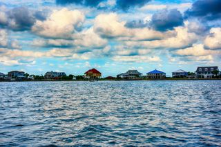 Houses on stilts in Slidell, Louisiana, as seen from the water.