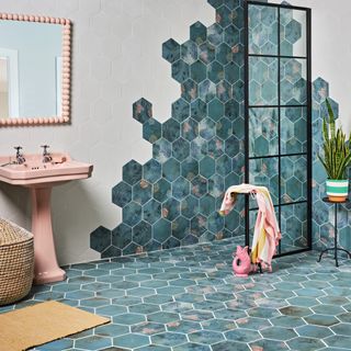 mermaid and ocean-inspired bathroom with blue tiles on wall and floor, scalloped fixtures, fish-inspired accessories and an open shower