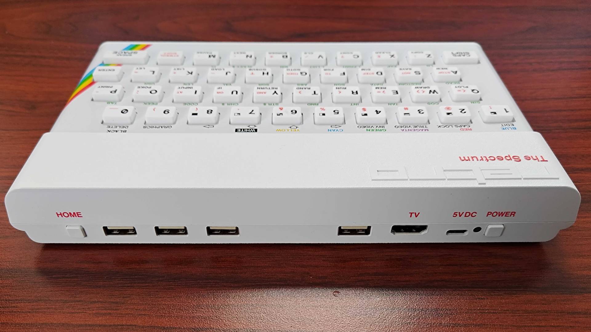 The Spectrum White Edition with ports in view on woodgrain desk.