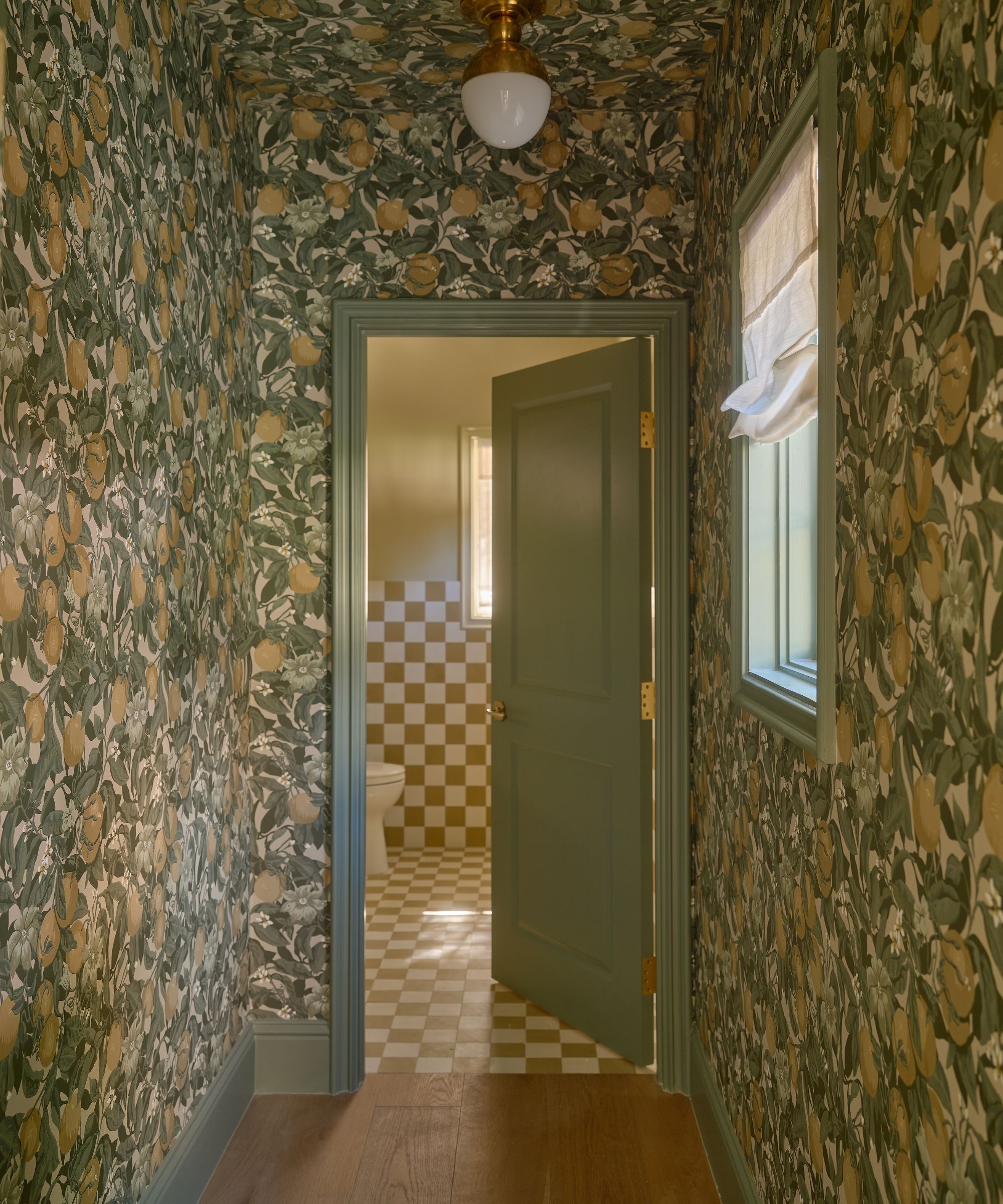 a wallpaper walkway into a powder room with yellow and white zellige tile checkered floor and walls