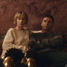 charles melton and cailee spaeny as a couple looking at each other sitting across from another couple played by carey mulligan and oscar isaac having a tense conversation in beef season 2