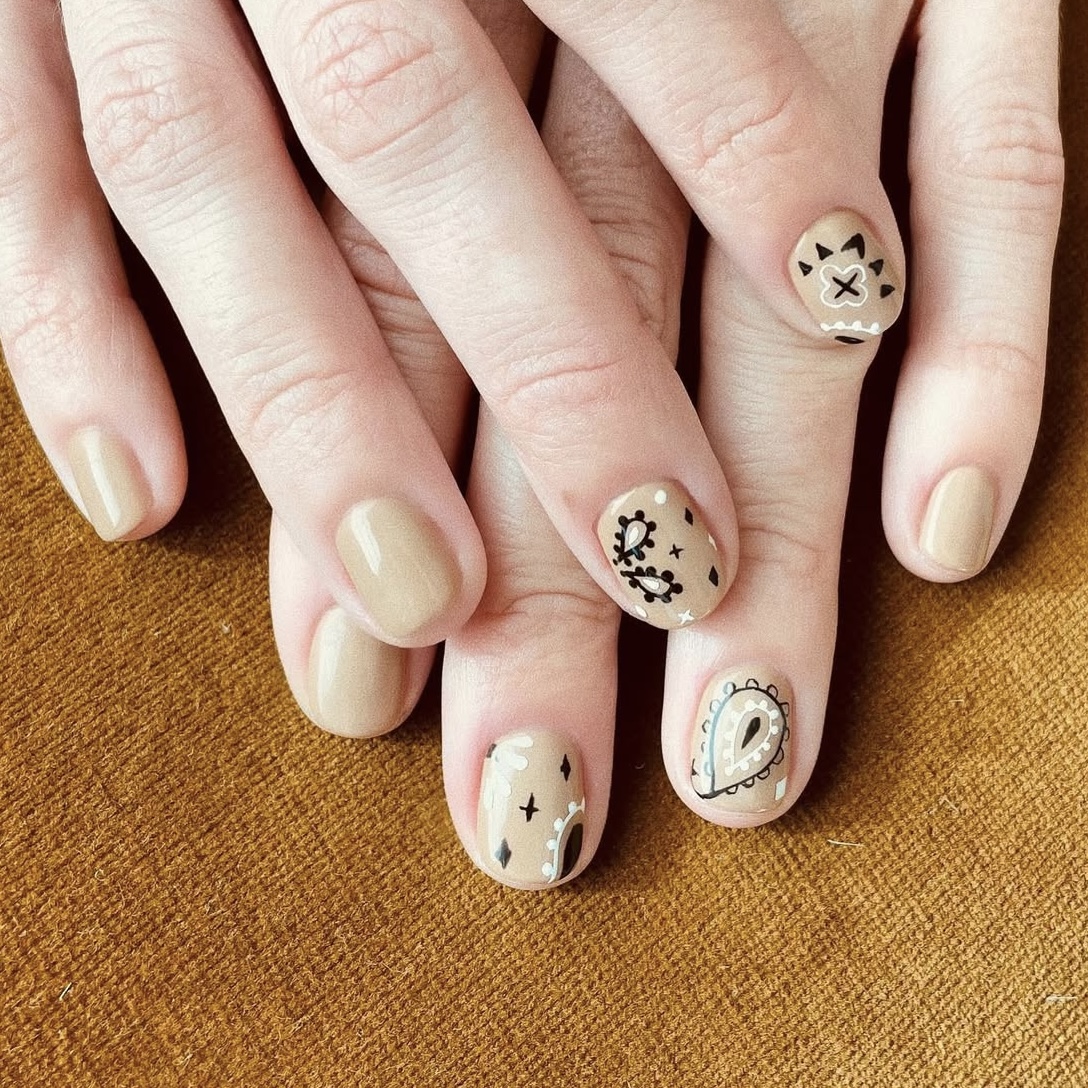 A nude manicure with paisley detailing.