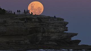 Spectators watch the total lunar eclipse of May 26, 2024, from Bondi Beach in Australia.