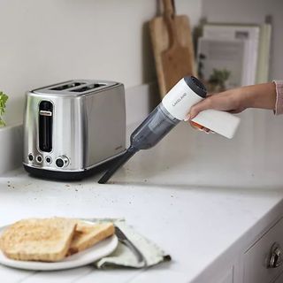 Using the Lakeland 3-in-1 Mini Vacuum Cleaner to vacuum toast crumbs next to a toaster