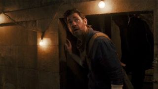 John Krasinski looking stunned while walking in a cavern in Fountain of Youth
