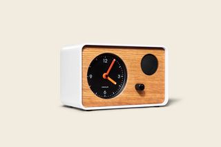 OneClock – a simple alarm clock with ‘waking music’. A white rectangular clock with a wooden front and a black clock on the front of it.