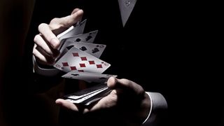 A close up of a person in a suit shuffling cards