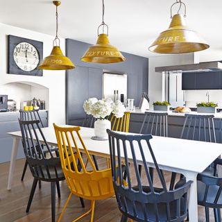 kitchen and dining area with wooden chairs in navy and yellow