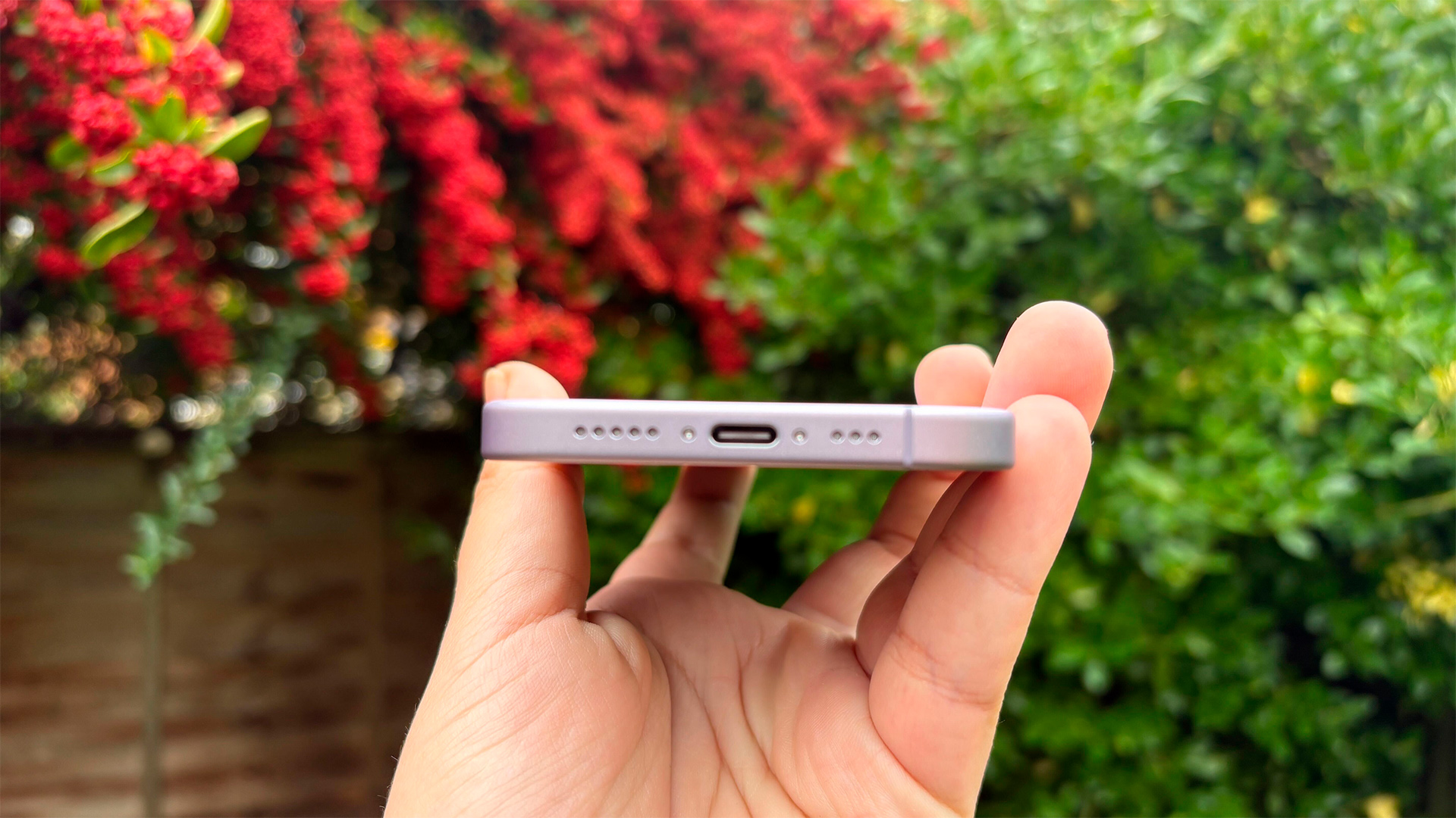 Apple iPhone 17 smartphone held in hand showing bottom mics and connection