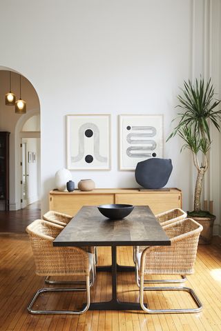 neutral dining room with rattan chairs and repeated wall art
