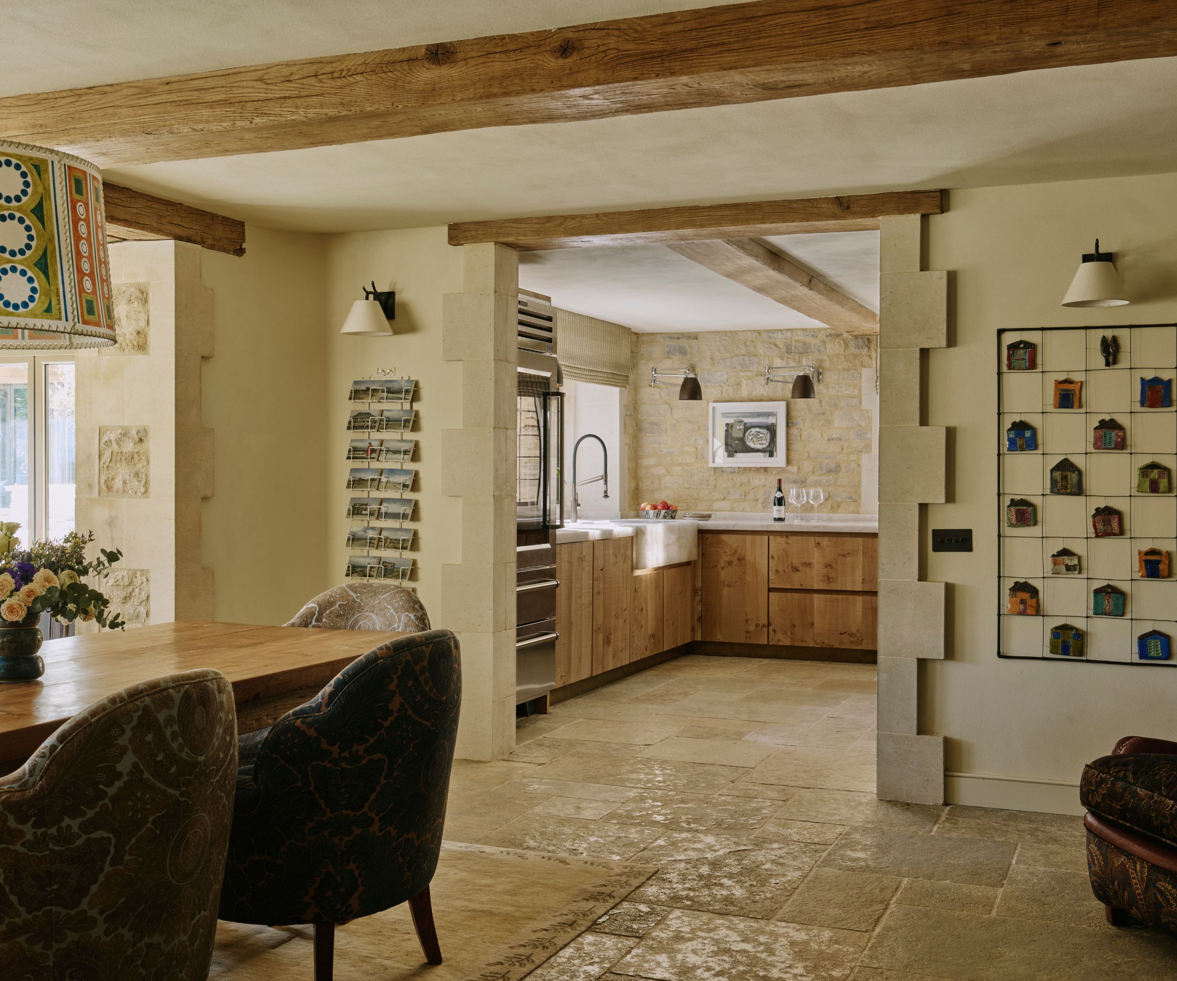 An open plan kitchen/dining area with neutral walls and stone flooring