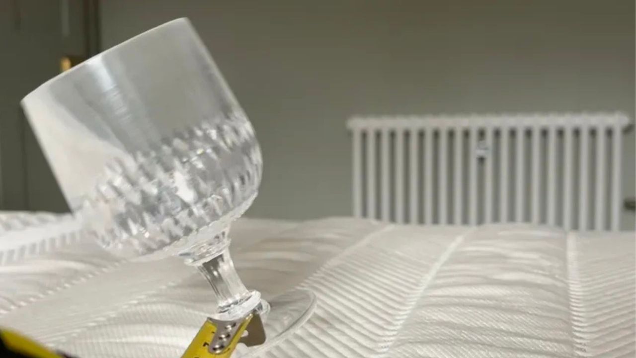 A wine glass falls over while balanced on the Leesa Leesa Hybrid Mattress during a motion isolation test