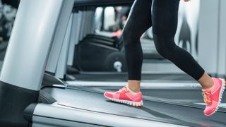 a woman's legs walking on a treadmill incline