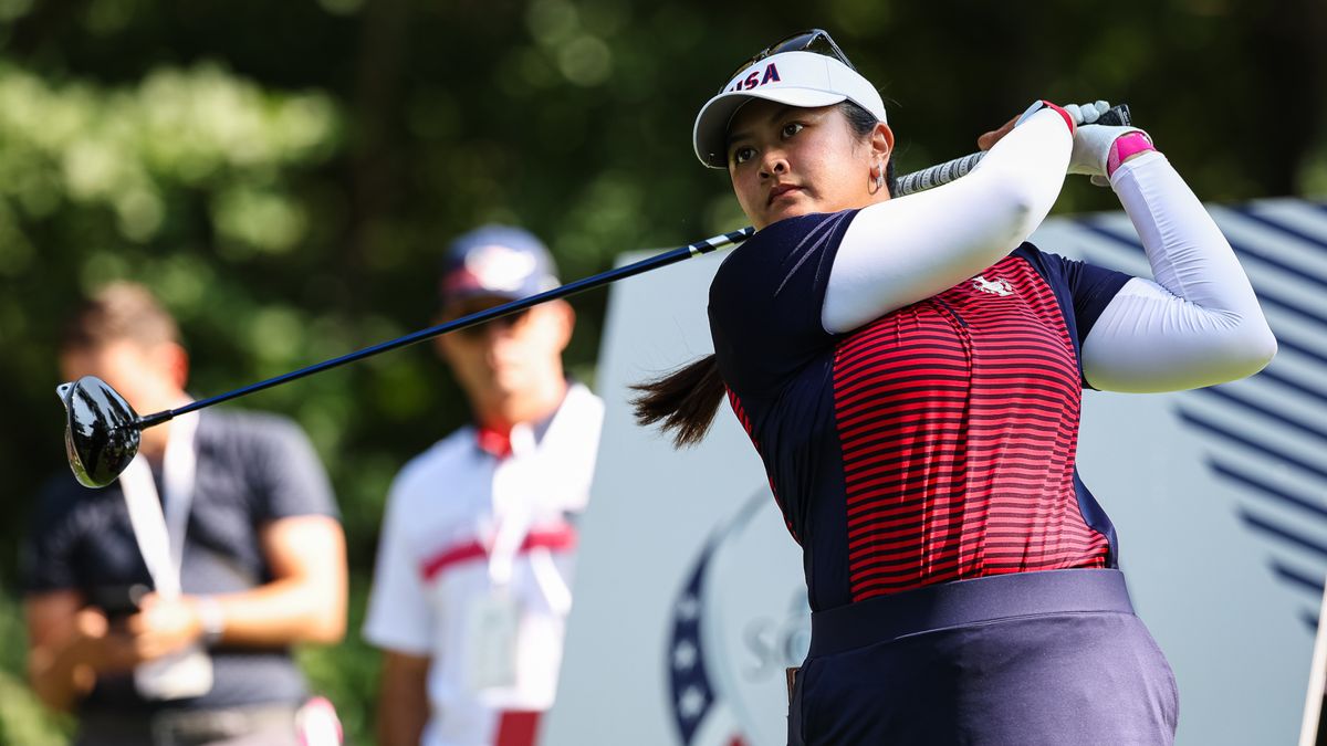 Lilia Vu, of Team USA, hits at tee shot at the 2024 Solheim Cup her red and blue striped team uniform and USA emblazoned white visor. 