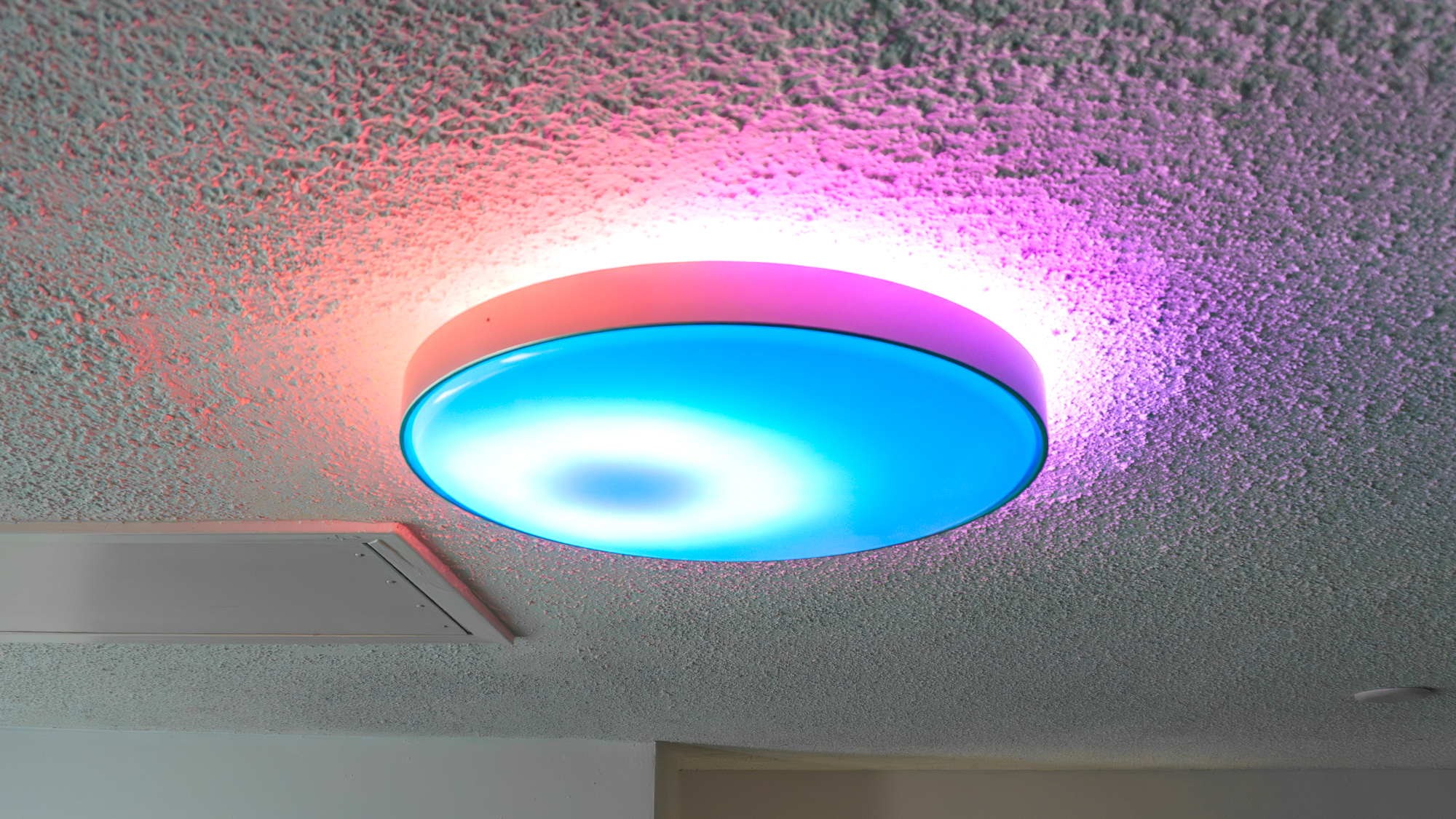The Govee Ceiling Light Ultra installed on a ceiling and synced with music playing on a smart speaker nearby