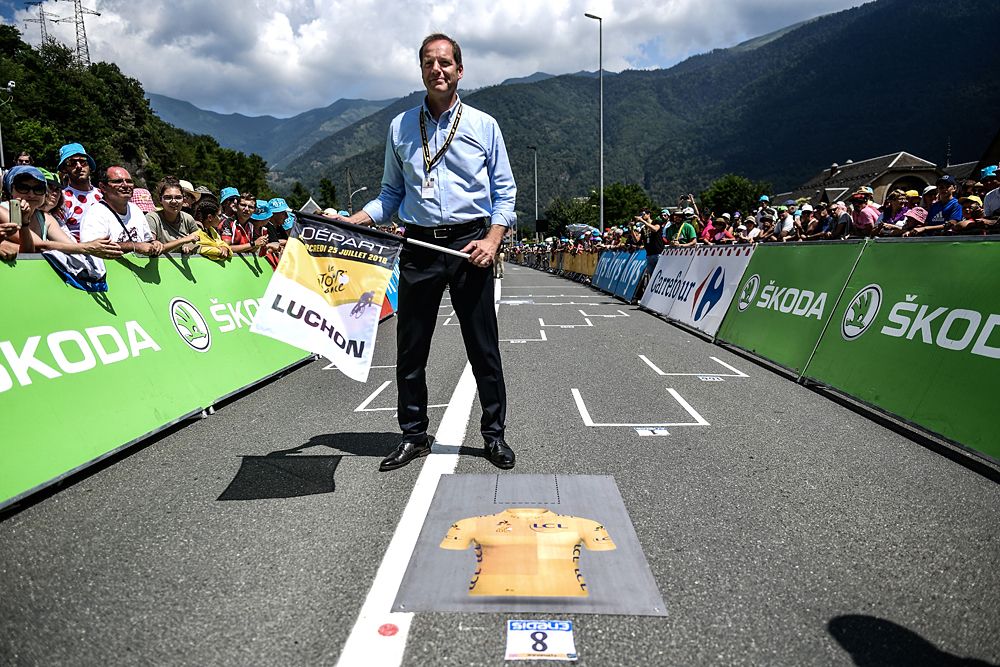 Tour de France director Christian Prudhomme holds the starting flag for the grid-start of stage 17
