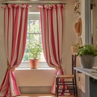 Living room with floor to ceiling striped pink sand cream curtains