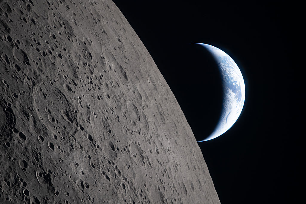 Photo of the moon with earth in the background captured by the Artemis mission