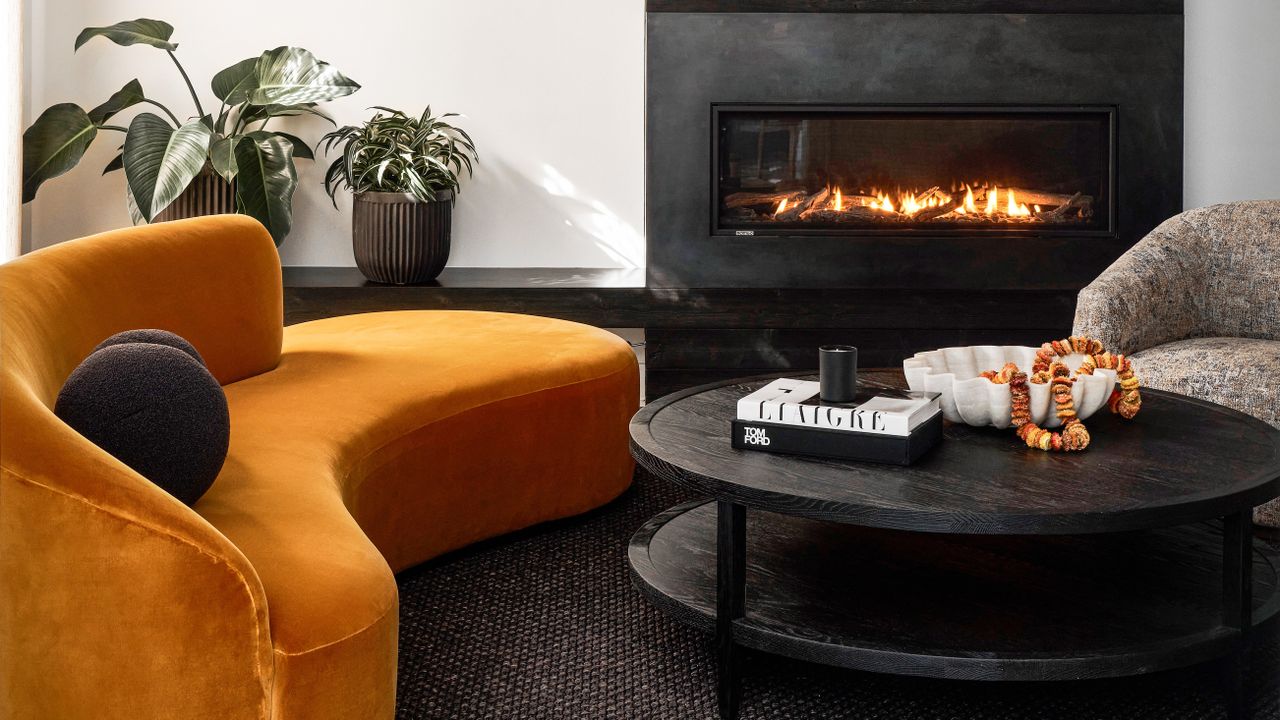 A living room with dark walls and a yellow sofa