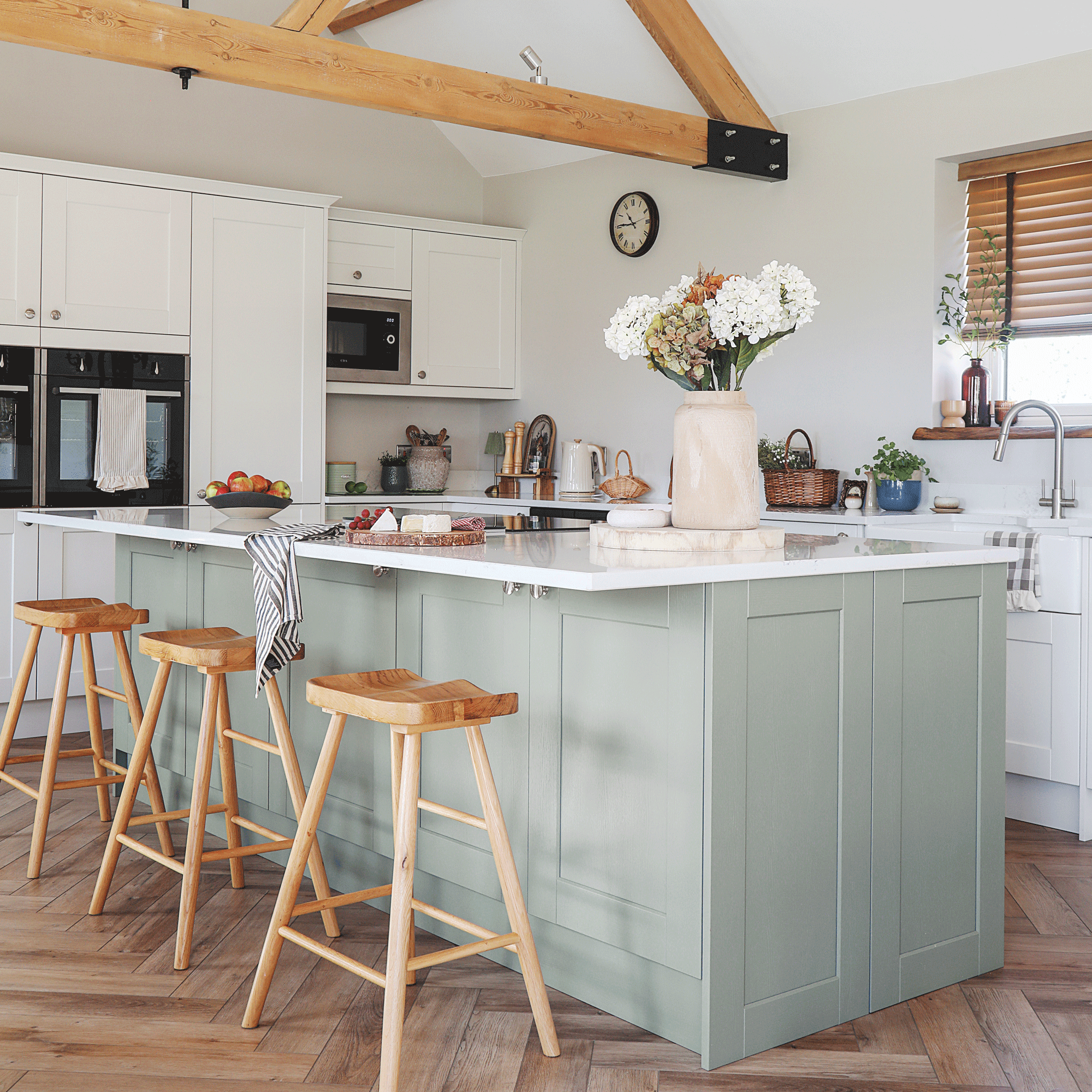 an open plan kitchen with vaulted ceilings and herringbone flooring