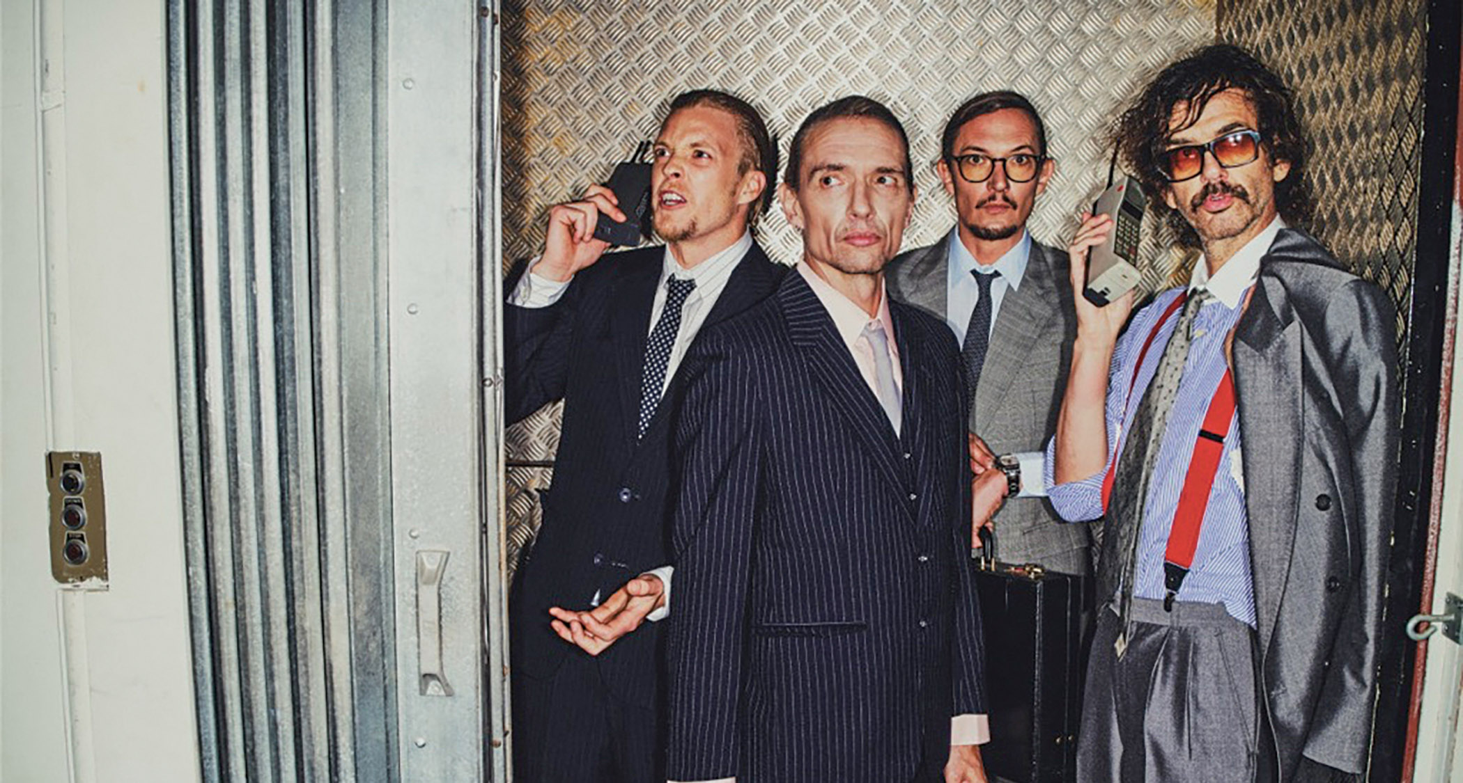 The Darkness are suited and booted and in a lift in this promo pic for their new LP, Dreams on Toast.