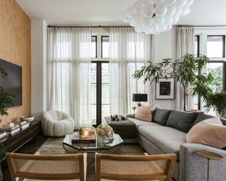 living room with neutral decor and statement pendant light