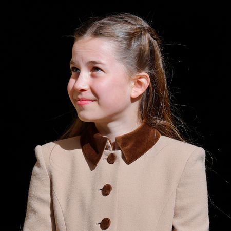 Princess Charlotte smiling in a tan coat