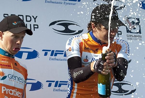 Stage winner Aaron Gate (Rabodirect New Zealand) releases the champagne whilst a bemused Patrick Shaw (Genesys Wealth Advisers) looks on.