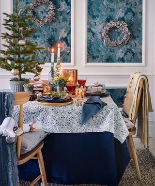 Christmas table centerpiece with blue walls and wreaths