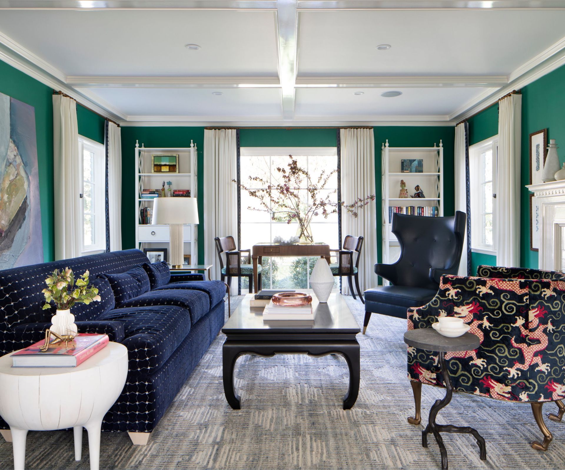 Living room in green with coffee table looking to backyard